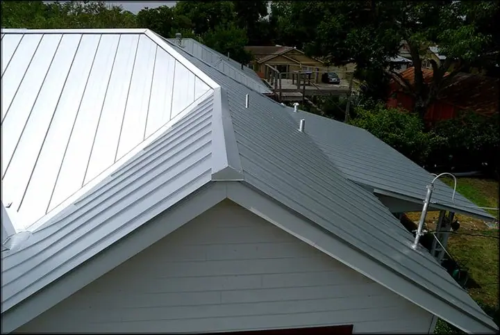 A finished silver metal roof over a home's gables
