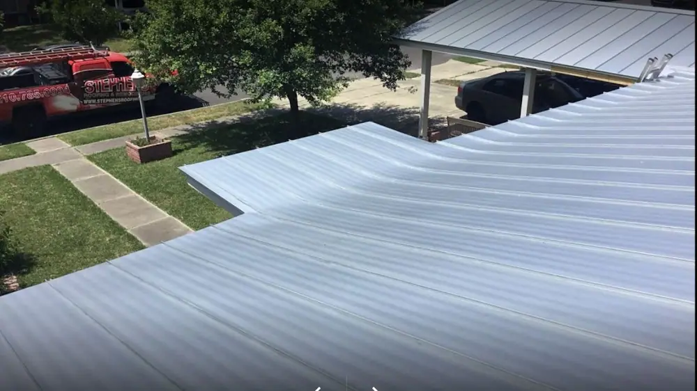 A silver metal roof over a home's carport and driveway